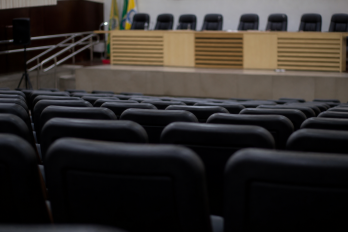 Auditório com cadeiras e palco ao fundo