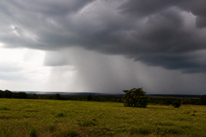 Nuvens de tempestade e cortina de chuva sobre campo aberto