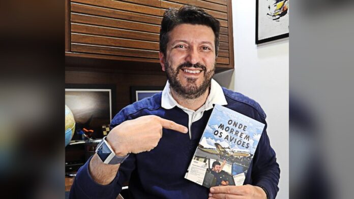 Lito Sousa segurando o livro Onde Morrem os Aviões