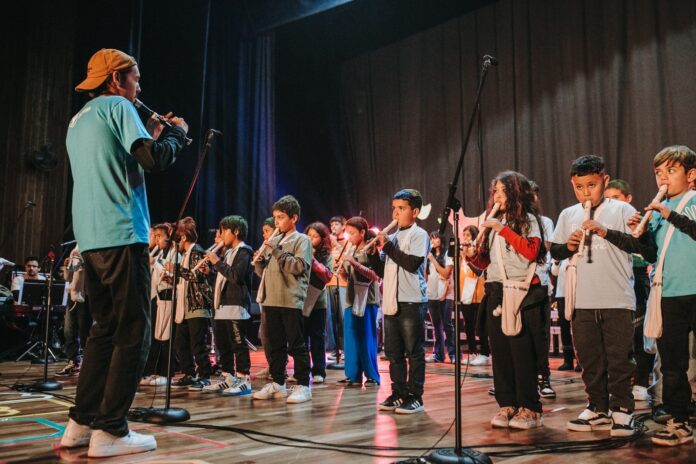Jovens do Projeto Dorcas tocando flauta durante apresentação